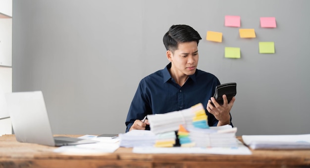 Mad crazy man employee sitting in office workplace with sticky notes all around shouting furious angry pissed off deadline and stressful job at office