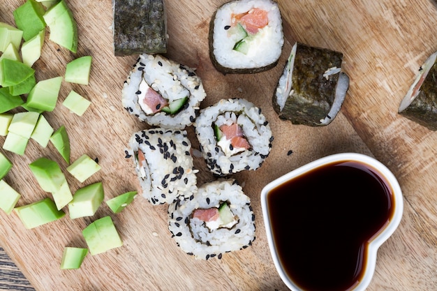 Made from rice and trout or salmon with vegetables sushi food with soy sauce, asian rice and seafood food on the table during meals, asian food items and soy sauce