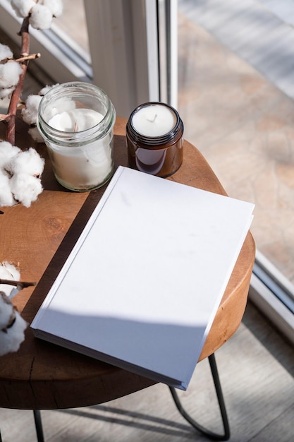 Magazine and book mockup design Blank magazine on modern wooden table with candles shadow overlay