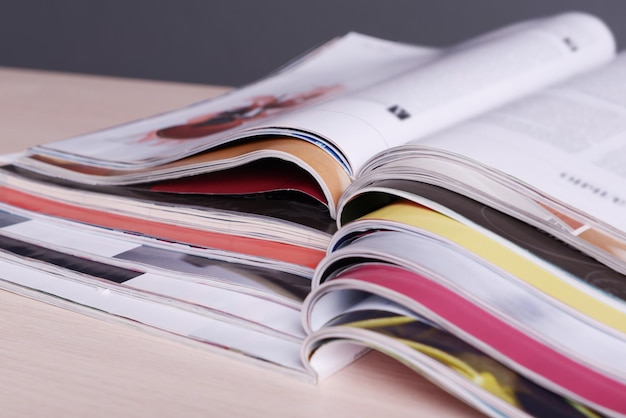 Magazines on wooden table on gray background