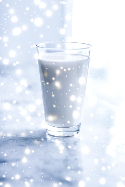 Magic holiday drink pouring organic lactose free milk into glass on marble table