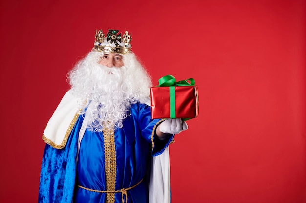 A magic king with a present on a red background