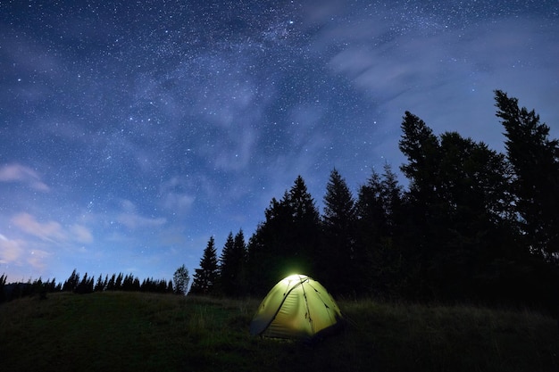 Magical starry night at a campsite in the mountains during summer time