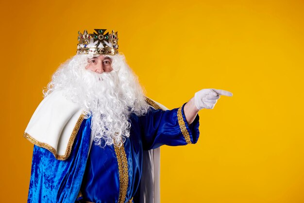 The Magician King pointing to a billboard on a yellow background