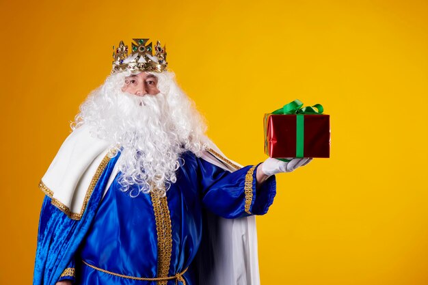 The Magician King with a present on a yellow background