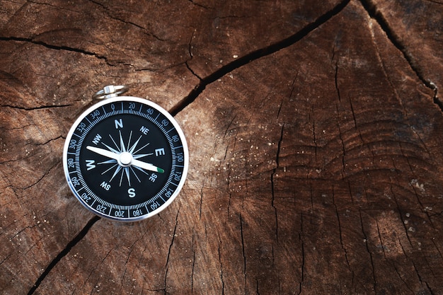 Magnetic compass on wooden background concept of global travel