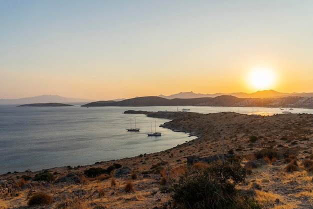 Magnificent landscape from the top point to the bay with yachts and the sun at sunset.