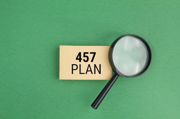 magnifying glass and brown paper with the number 457 Plan. 457 plan concept