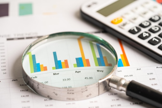 Magnifying glass on charts graphs paper Financial development Banking Account Statistics Investment Analytic research data economy Stock exchange trading Business office company meeting concept