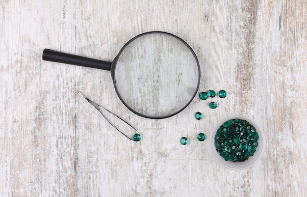 magnifying glass and emeralds on the table