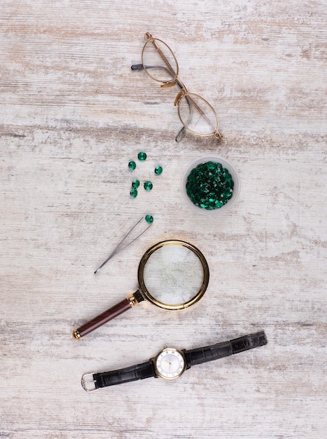 magnifying glass and emeralds on the table