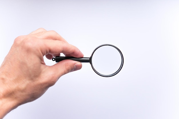 Magnifying glass in hand on white background isolated, copy space for your image or text