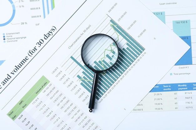 Magnifying glass and papers with diagrams top view