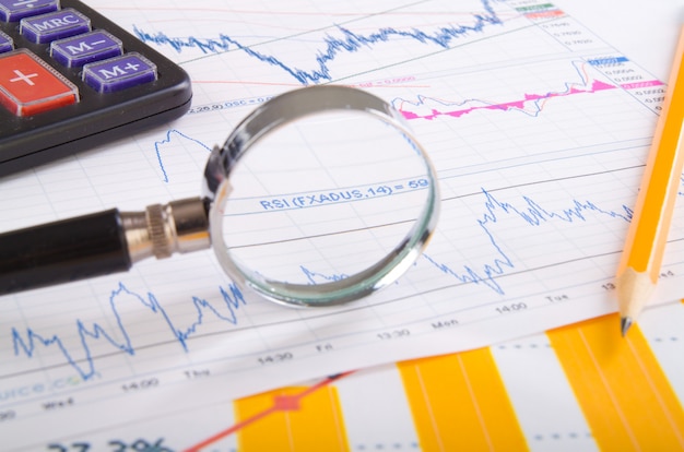 Magnifying glass on top of financial market info