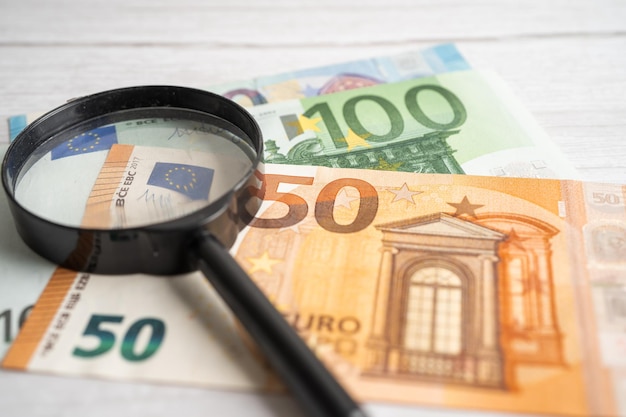 Magnifying glass with EU banknotes background Banking Account Investment Analytic research data economy trading Business company concept