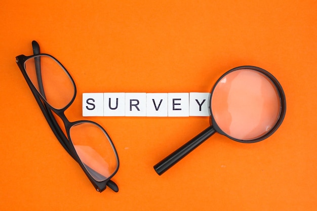 magnifying glass with the word survey alphabet letters the concept of surveying or analyzing