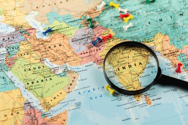 magnifying glass on the world map selective focus at india. - economic and business concept.