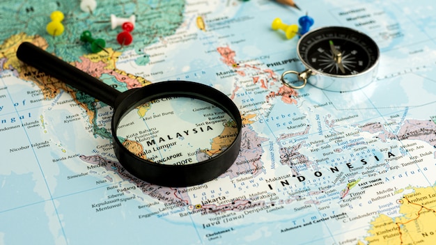 Magnifying glass on the world map selective focus at Malaysia map. - economic and business concept.