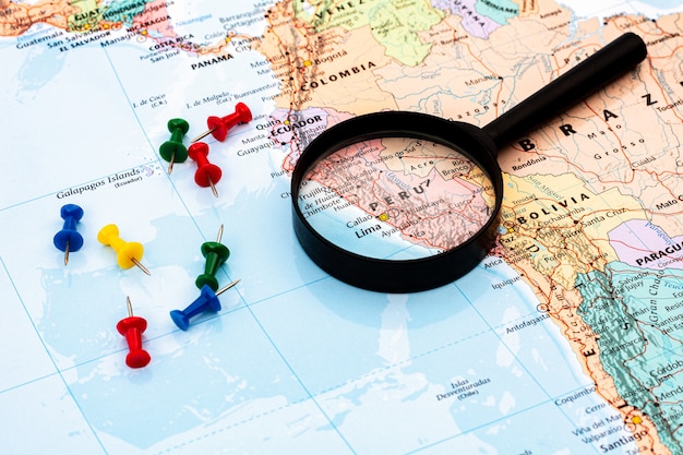 Magnifying glass on the world map selective focus at peru.  economic and business .