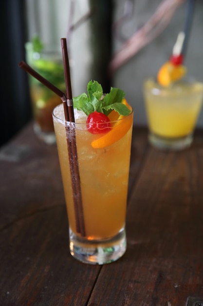 Mai tai cocktail with orange cherry fruits on wood background