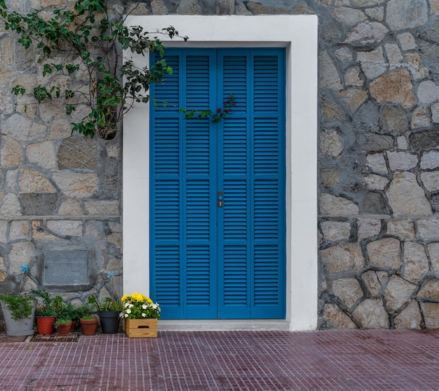 Main blue colored of a town house decorated with flowers.