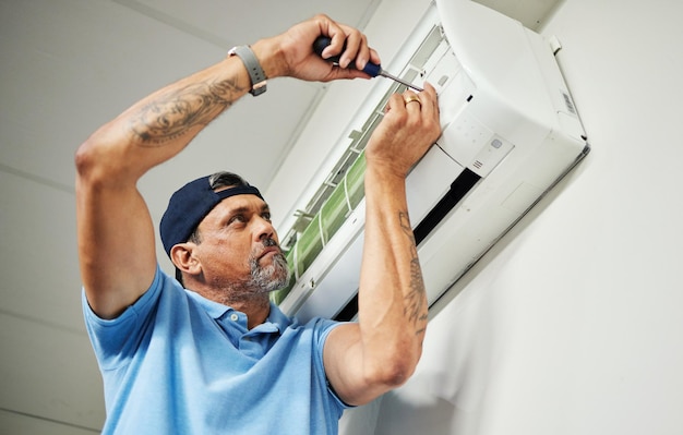 Maintenance ac repair and air conditioner with man and screwdriver for electrician ventilation and power Engineering electricity and inspection with technician and tools for fan and contractor