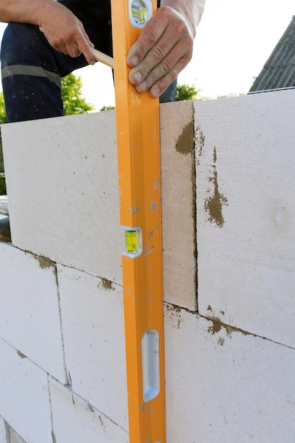 Maintenance worker holding aluminium spirit level tool or bubble levels at construction site Equipment for civil engineering projec