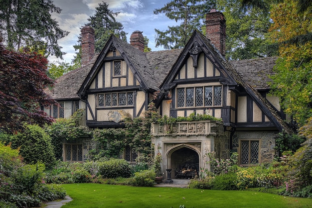 Majestic halftimbered Tudor mansion adorned with lush greenery intricate architecture and a picturesque garden under a serenely cloudy sky