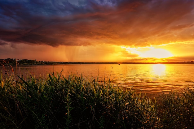 Majestic Sunset over the Lake with Stripes of Rain in the Distance