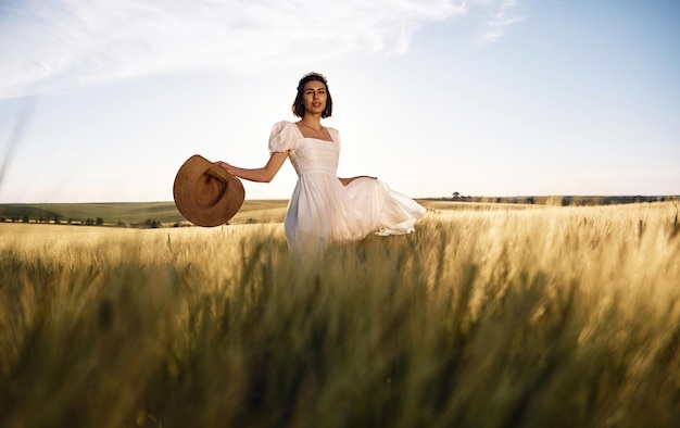 Majestic view Beautiful young bride in white dress is on the agricultural field at sunny day