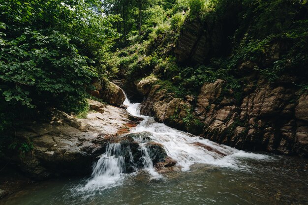 Majestic waterfall in the mountains of Russia.