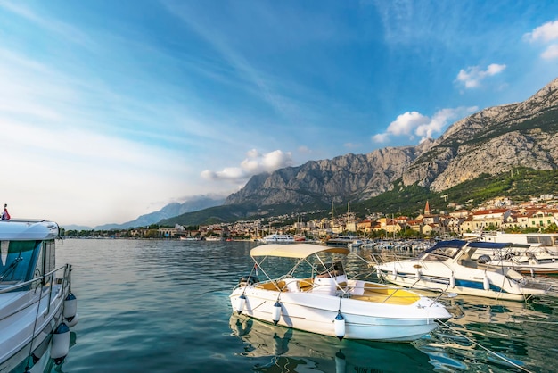 Makarska, Croatia. A view of yachts and the old town and the sky at sunset.