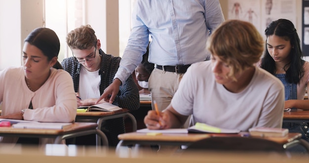 Make today the day you learn something new Shot of teenage boy asking his teacher for help during an exam in a classroom