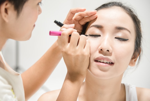 Make up artist applying make up to clean face a fashion model or bride