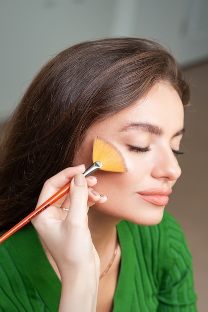 Make up artist applying professional make up of tonal foundation