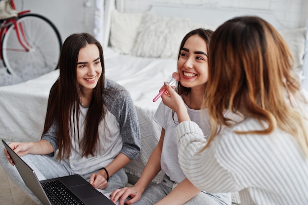 Make up artist prepare two twins models with laptop on studio before photoshoot