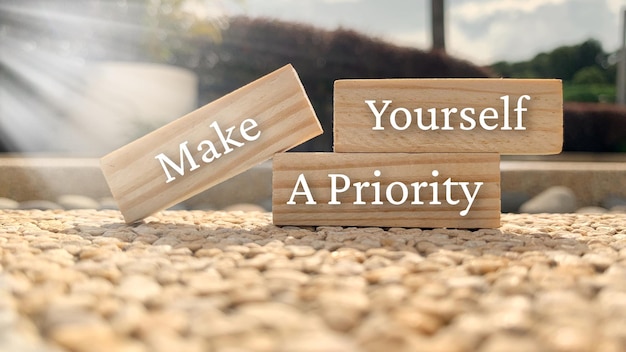 Make yourself a priority text on wooden blocks with bright sun and park background