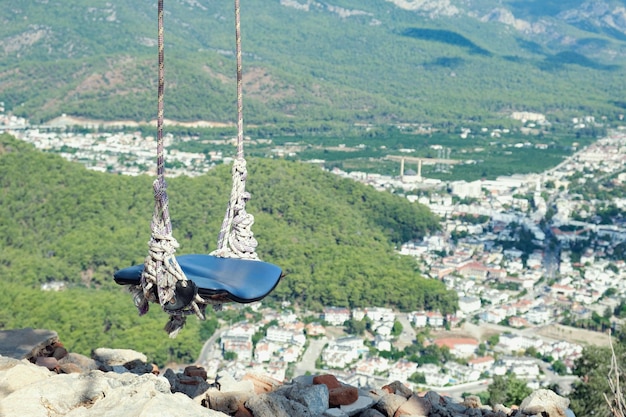 Makeshift swing on a rope twine over an observation deck in the mountains