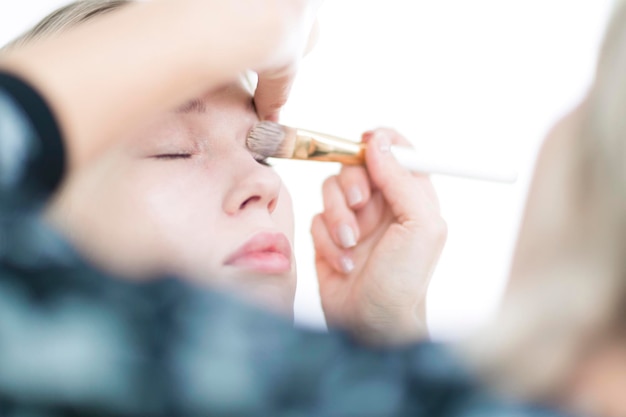 Makeup artist applies a liquid foundation in the studio Closeup