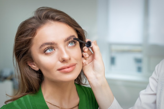 Makeup artist applying mascara on lashes