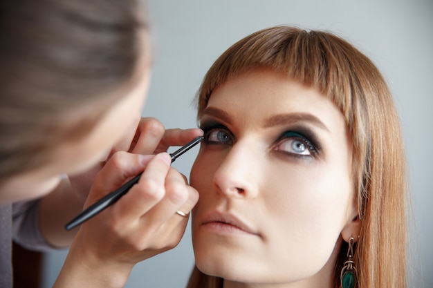 Makeup artist glues false eyelashes