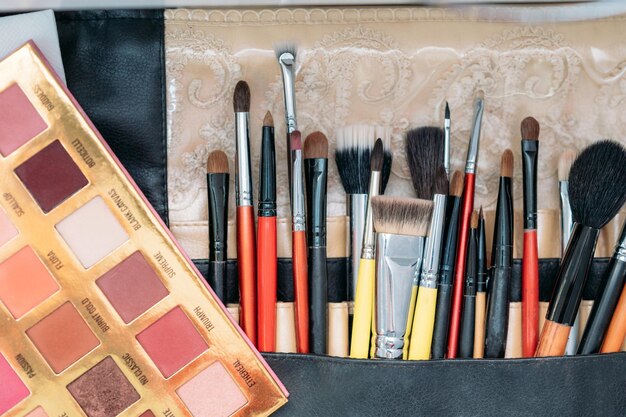 Makeup brushes are in a drawer at the makeup artist's workplace closeup