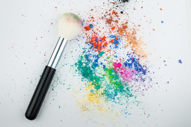 Makeup Brushes on White Background with Colorful Pigment Powder