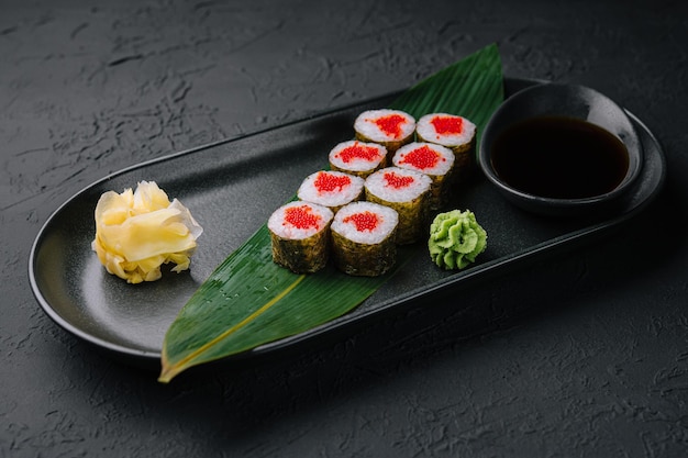 Maki Sushi with red caviar on black plate