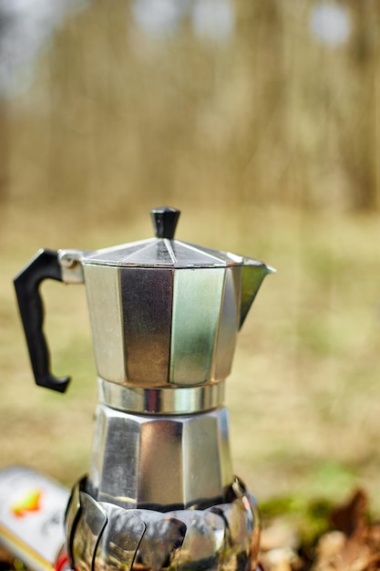 Making camping coffee from a geyser coffee maker on a gas burner