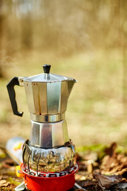 Making camping coffee from a geyser coffee maker on a gas burner