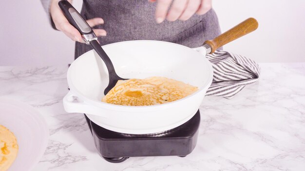 Making crepes in a small frying pan over medium heat.