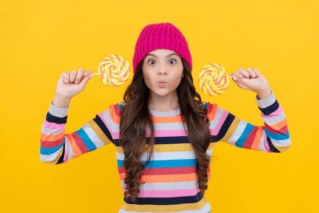 Making face lollipop lady hipster kid with colorful lollypop sugar candy on stick caramel candy shop sweet childhood concept of dental care sweet tooth yummy funny teen girl hold lollipop