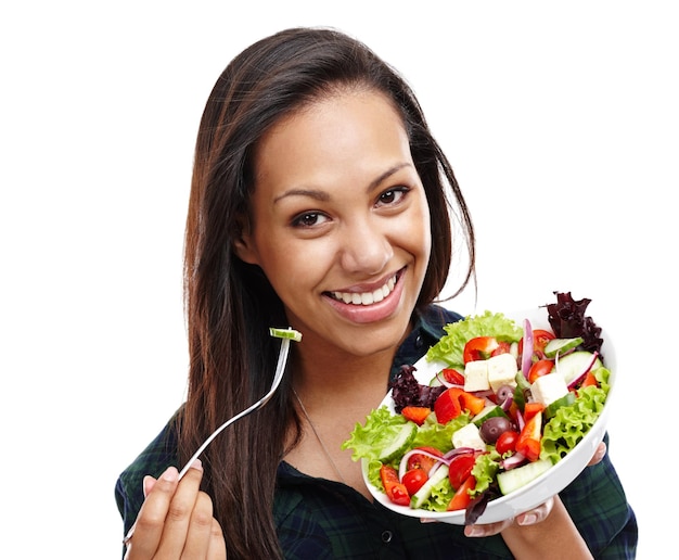 Making the healthy choice Portrait of an attractive young woman enjoying a bowl of salad isolated on white