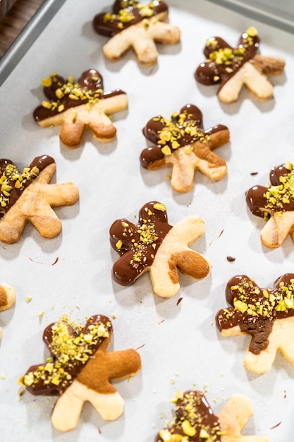 Making holiday star cookies chocolatedipped with pistachio topping